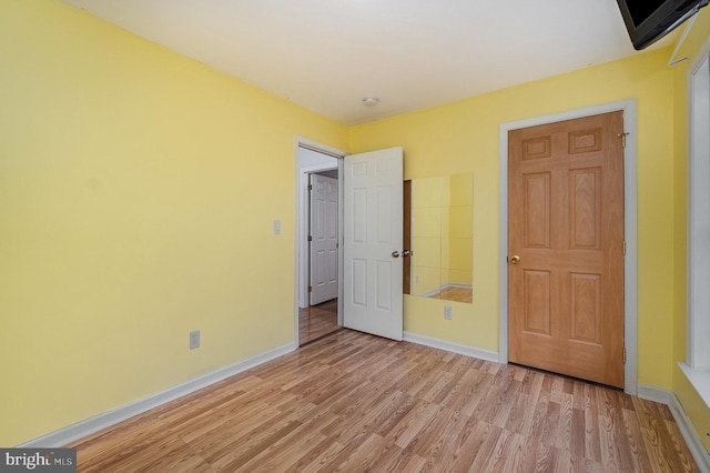 unfurnished bedroom with baseboards and light wood finished floors