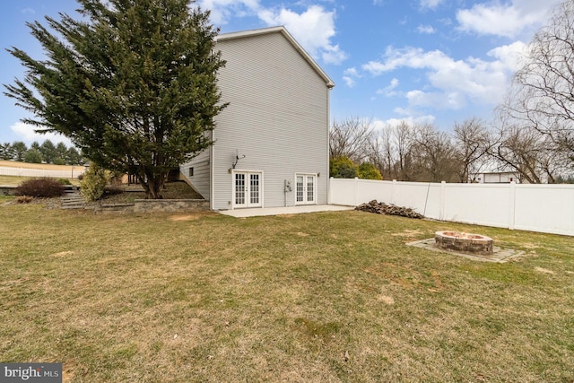 view of yard with french doors, a fire pit, a patio, and fence