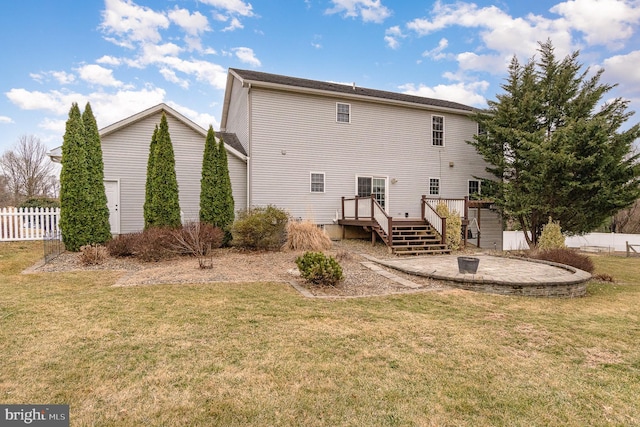 rear view of house with a patio, a yard, fence, and a wooden deck