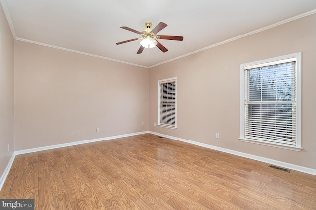 spare room with visible vents, crown molding, light wood-style floors, and ceiling fan