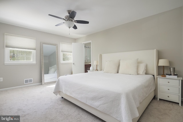 bedroom featuring visible vents, multiple windows, light colored carpet, and baseboards