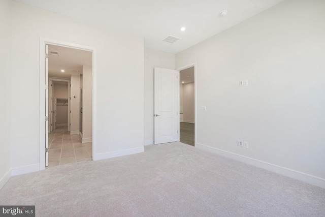 unfurnished bedroom with visible vents, recessed lighting, baseboards, and light carpet