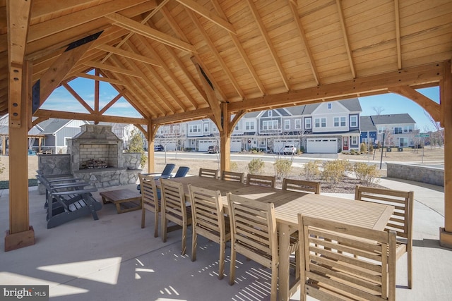 view of patio featuring a gazebo, an outdoor stone fireplace, and outdoor dining space