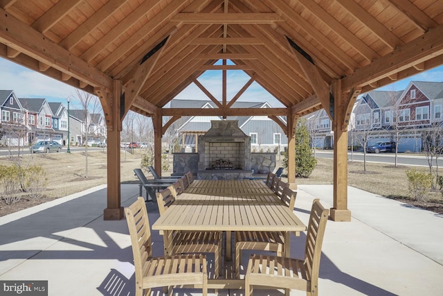 view of patio / terrace with a gazebo, a residential view, and an outdoor stone fireplace