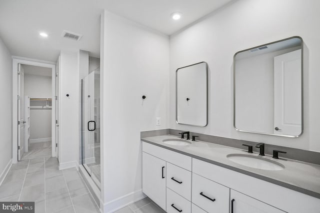 bathroom with a sink, visible vents, a spacious closet, and a shower stall