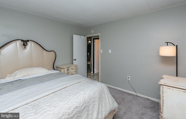 bedroom featuring a textured ceiling, carpet, and baseboards