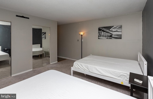 carpeted bedroom featuring a textured ceiling and baseboards