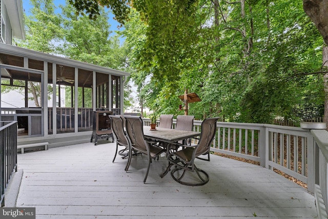 deck featuring outdoor dining area and a sunroom