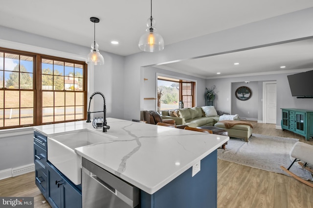 kitchen with a sink, blue cabinetry, light wood-style floors, and stainless steel dishwasher