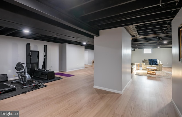 exercise area with baseboards and wood finished floors