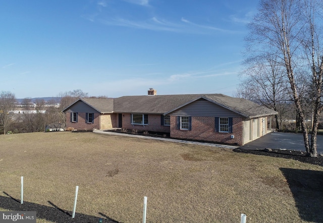 ranch-style home with a front yard, driveway, an attached garage, a chimney, and brick siding