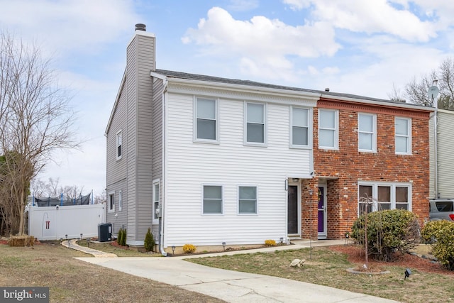 townhome / multi-family property with a chimney, central AC, and fence