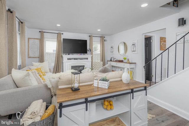 living area with stairs, wood finished floors, recessed lighting, and baseboards