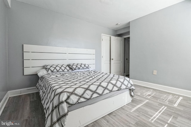 bedroom featuring baseboards and wood finished floors