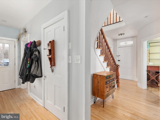 entrance foyer featuring light wood finished floors, stairs, and baseboards