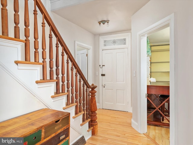 entryway with stairway, baseboards, visible vents, and light wood finished floors