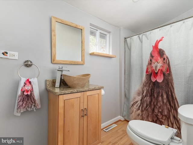 full bath featuring visible vents, baseboards, toilet, wood finished floors, and vanity