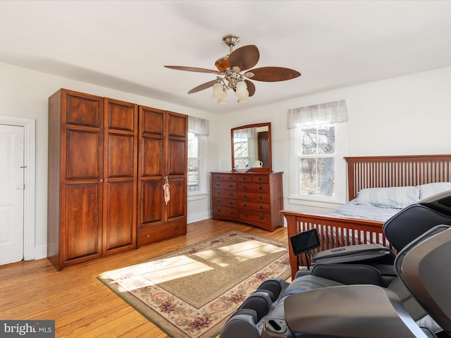 bedroom featuring baseboards, light wood-style flooring, and a ceiling fan