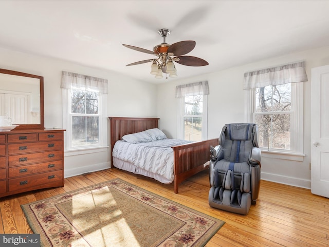 bedroom featuring a ceiling fan, baseboards, and hardwood / wood-style flooring