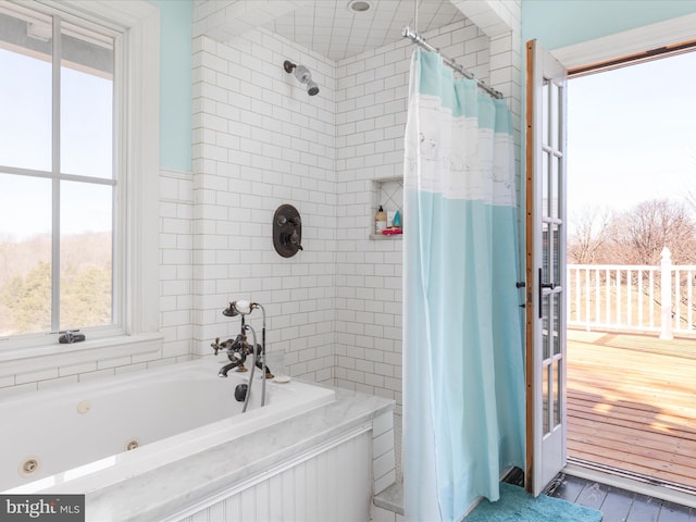 bathroom featuring a jetted tub, a shower with shower curtain, and wood finished floors