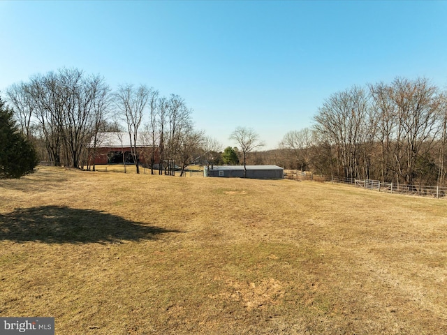 view of yard with a rural view and fence