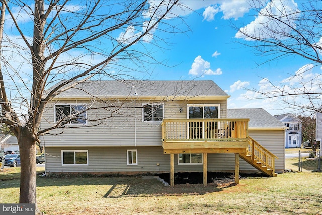 back of house with stairway, a lawn, fence, and a wooden deck