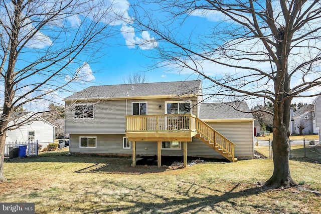 rear view of house with a wooden deck, a yard, stairs, and fence