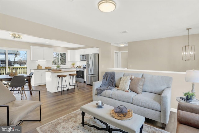 living area with an inviting chandelier and wood finished floors