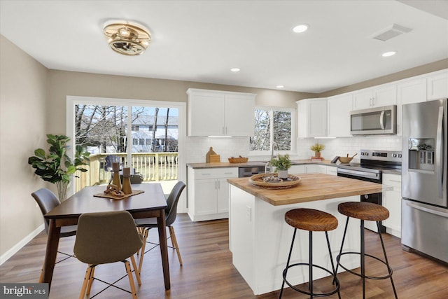 kitchen featuring plenty of natural light, visible vents, appliances with stainless steel finishes, and wooden counters