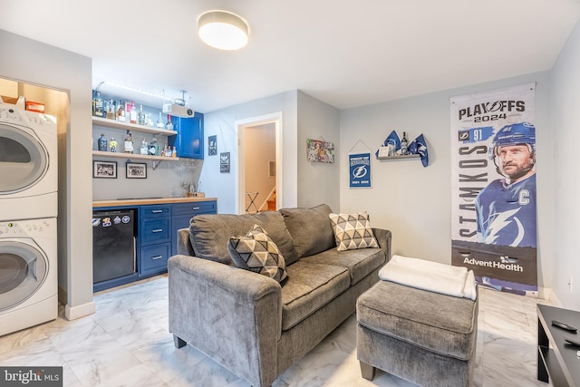 living area with stairs, stacked washer / dryer, bar area, and marble finish floor