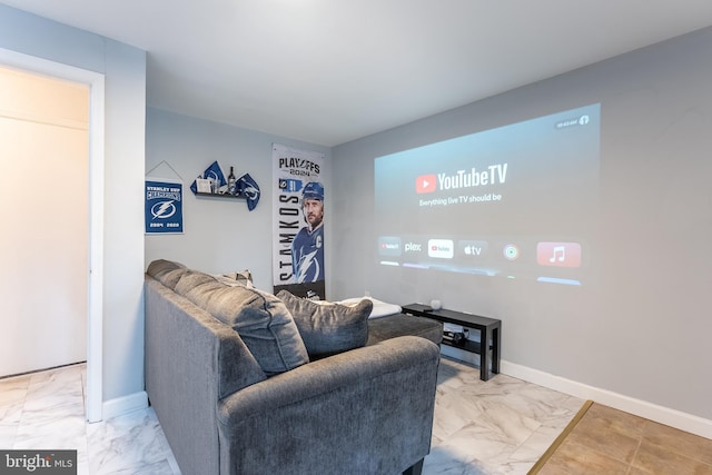 living area featuring marble finish floor and baseboards