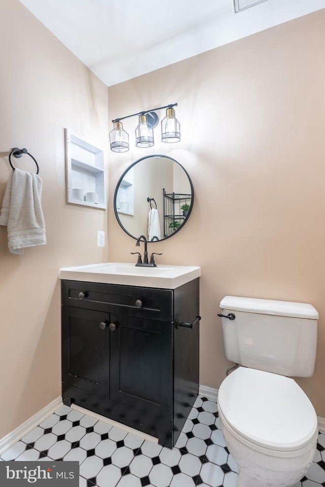 bathroom featuring tile patterned floors, toilet, vanity, and baseboards