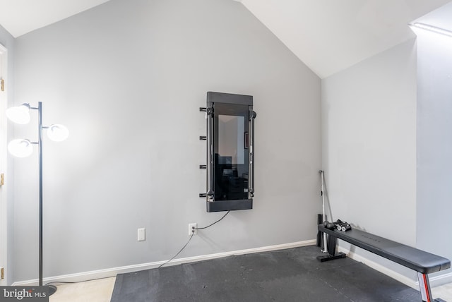 workout room featuring baseboards and lofted ceiling