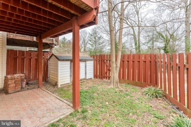 view of yard featuring an outbuilding, a storage shed, a patio, and a fenced backyard