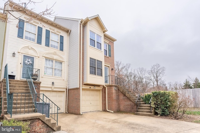 townhome / multi-family property with stairway, a garage, and concrete driveway