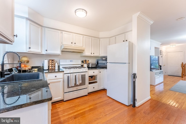 kitchen featuring a sink, under cabinet range hood, white appliances, light wood-style floors, and white cabinets