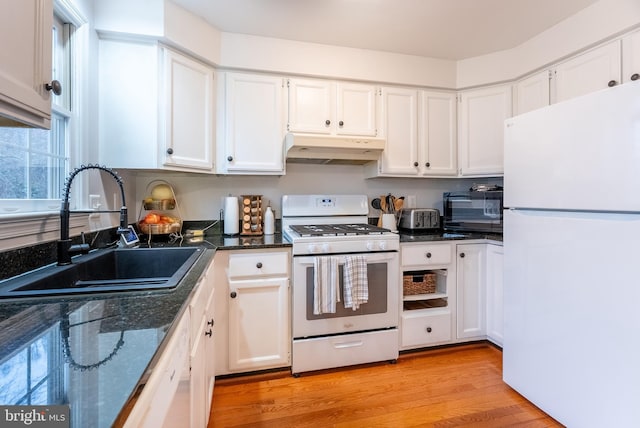 kitchen with under cabinet range hood, white appliances, white cabinetry, and a sink