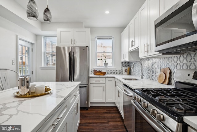 kitchen featuring white cabinets, tasteful backsplash, appliances with stainless steel finishes, and a sink