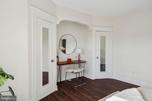 interior space with baseboards and wood finished floors