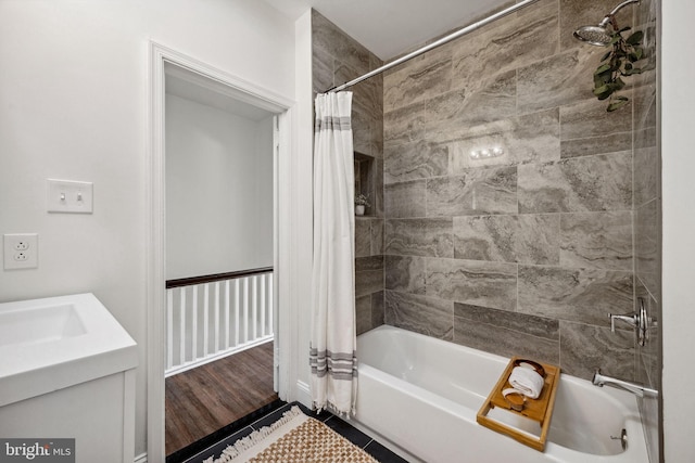 bathroom featuring tile patterned flooring, a sink, and shower / bathtub combination with curtain