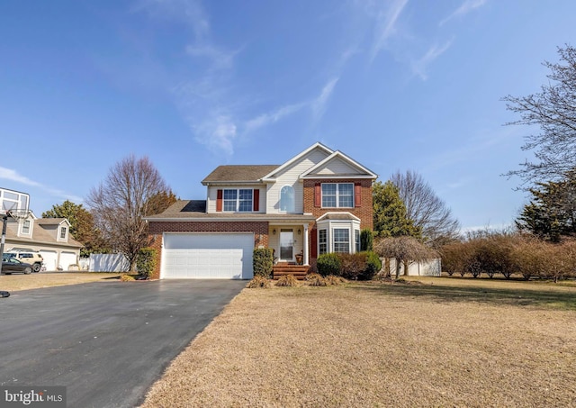 traditional-style house featuring aphalt driveway, a front yard, brick siding, and an attached garage