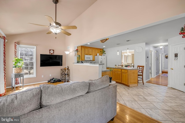 living room featuring light wood-style flooring, baseboards, high vaulted ceiling, and ceiling fan