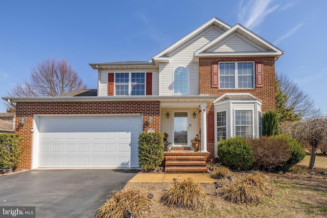 traditional-style house featuring aphalt driveway, a garage, and brick siding