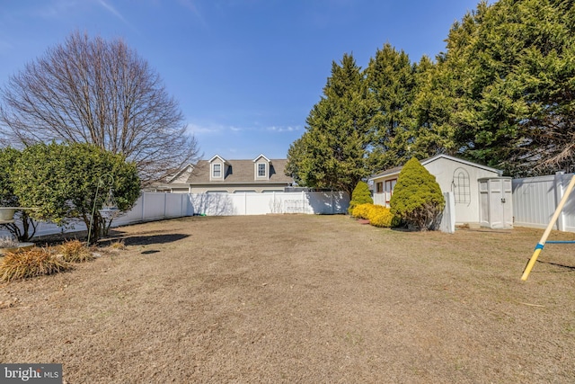 view of yard with a shed, an outdoor structure, and a fenced backyard