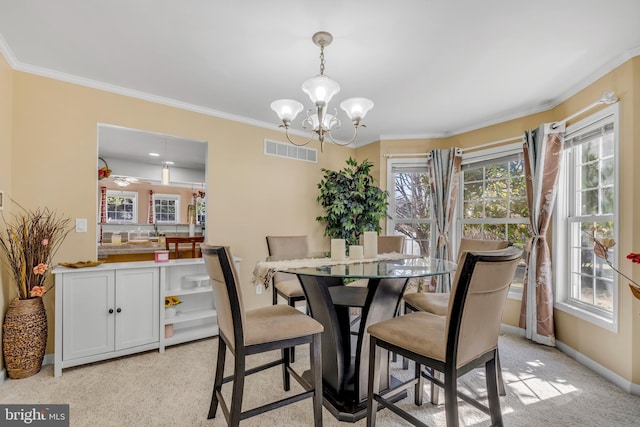 dining area featuring crown molding, a notable chandelier, baseboards, and visible vents