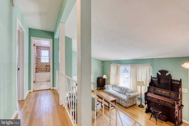 interior space with baseboards, wood-type flooring, and a healthy amount of sunlight