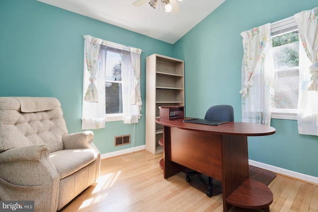 office with visible vents, a ceiling fan, baseboards, and wood finished floors