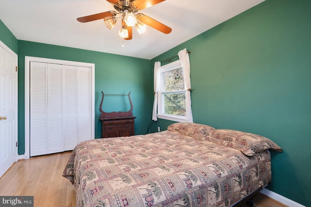 bedroom with a closet, ceiling fan, baseboards, and wood finished floors