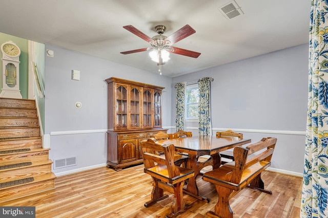 dining space with light wood-style floors, a ceiling fan, visible vents, and baseboards