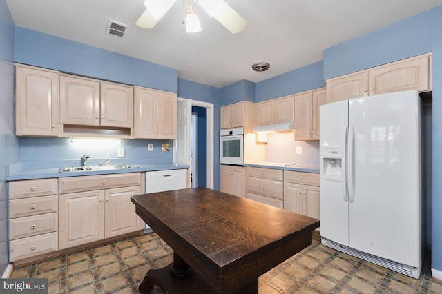 kitchen with white appliances, light brown cabinets, a sink, under cabinet range hood, and tile patterned floors